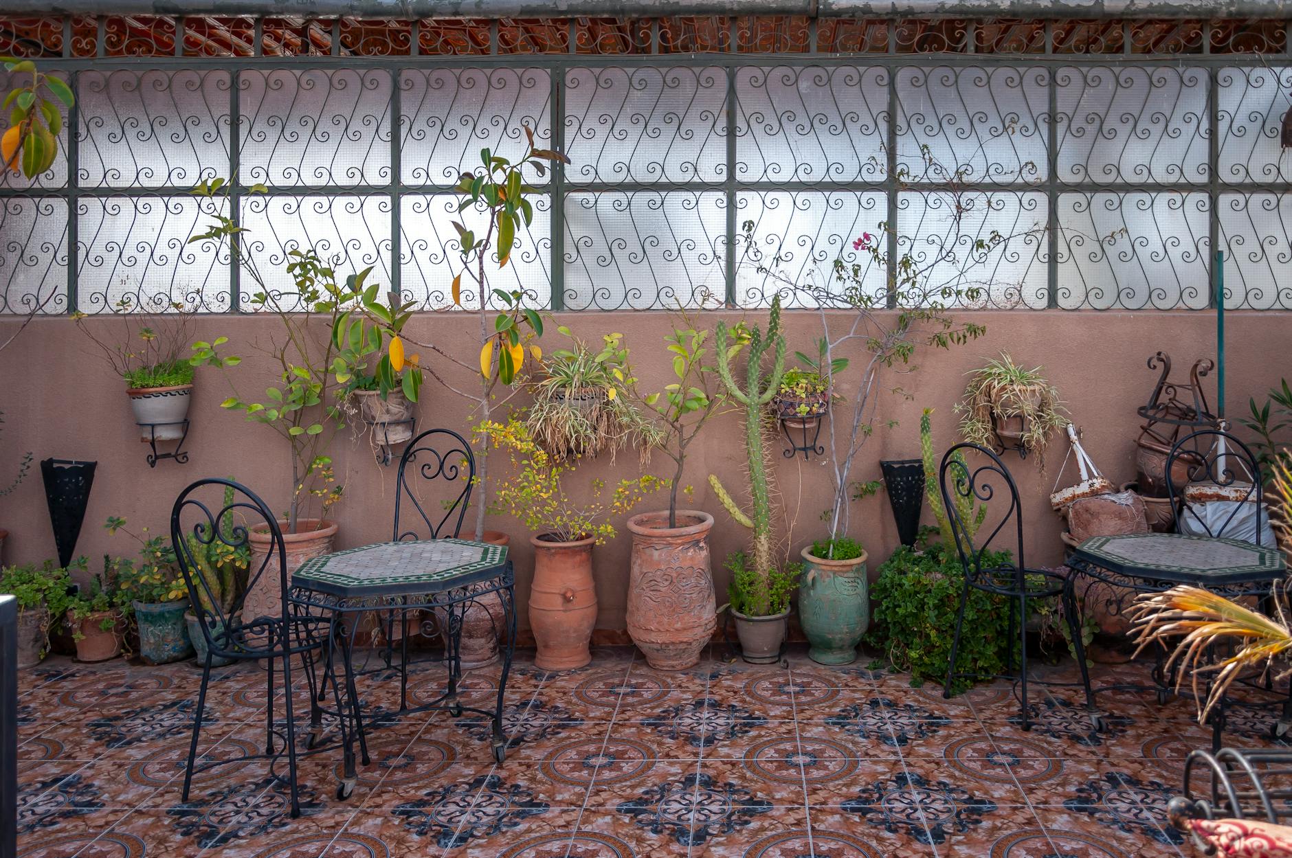 A cozy balcony with comfortable seating and potted plants.