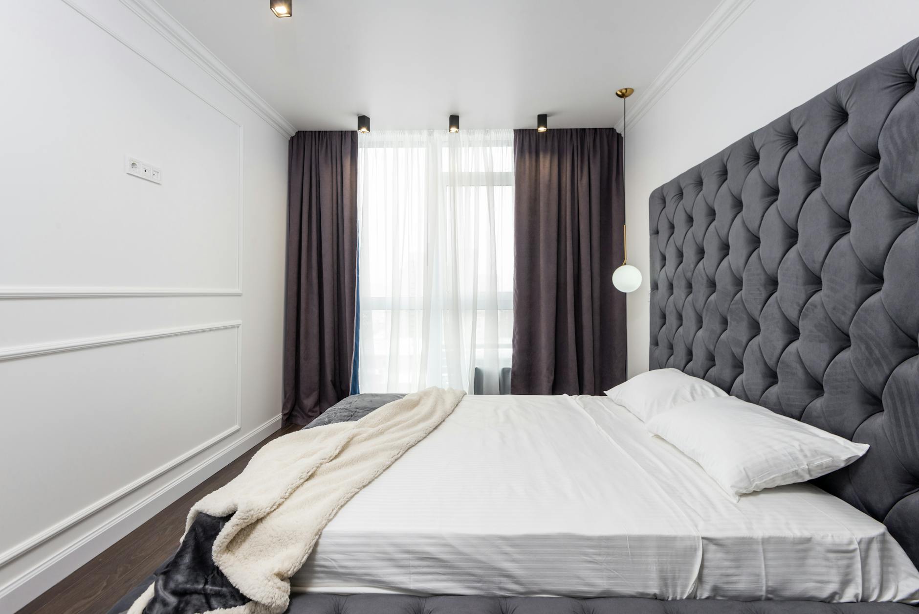 A traditionally placed bed centered on a wall with nightstands.