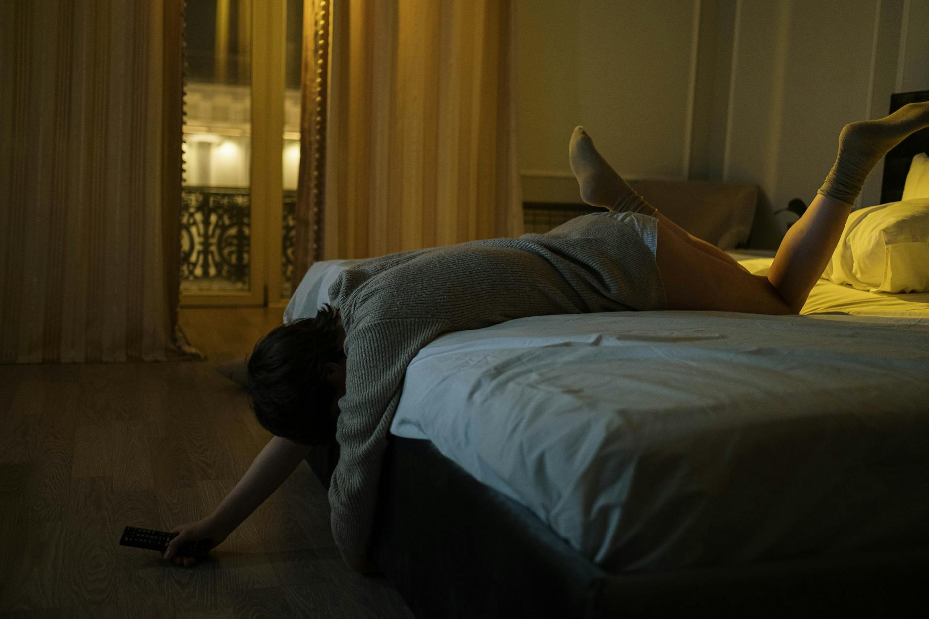 A tidy bedroom with a smartphone and tablet charging on a nightstand.