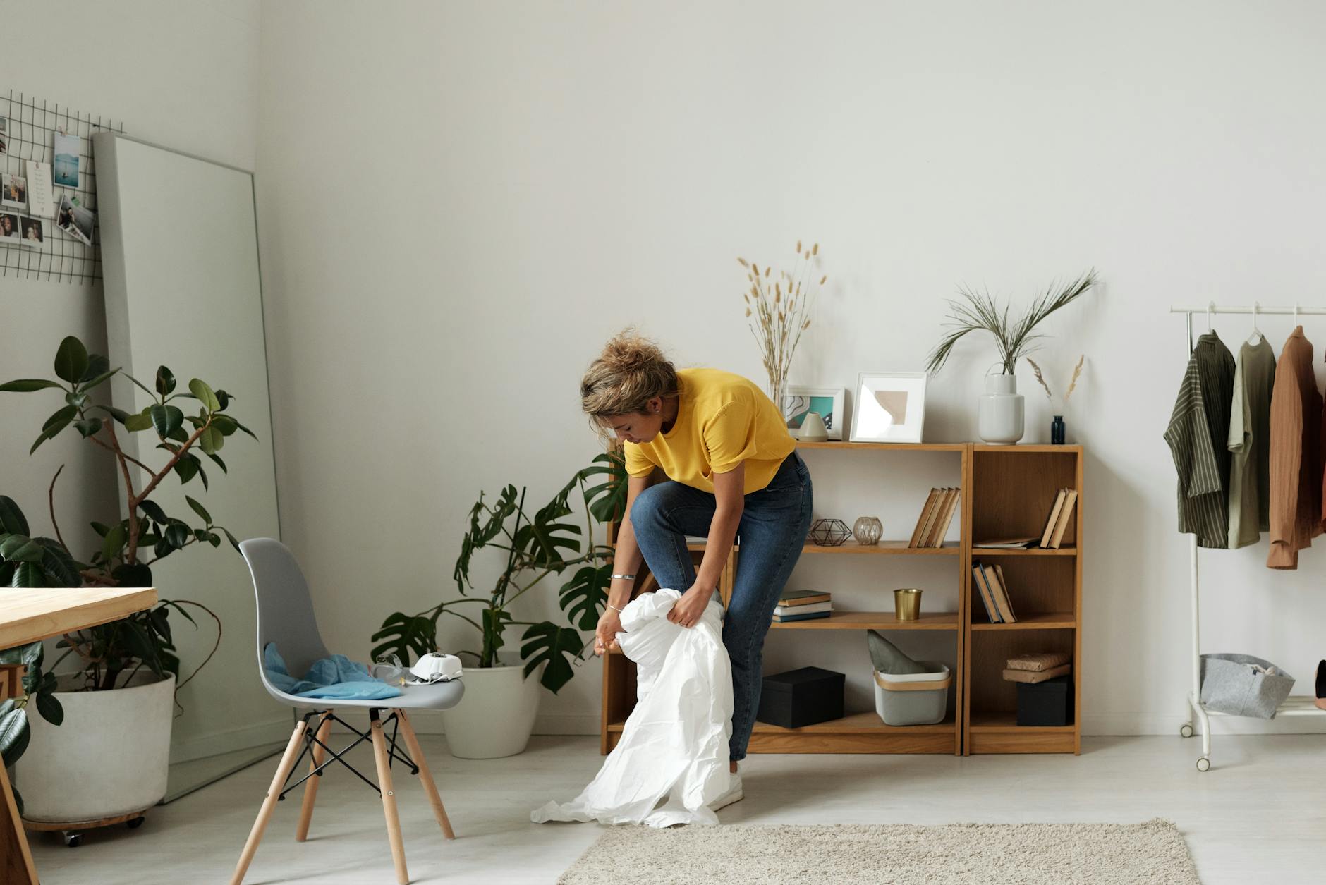 A person meditating in a room's wealth corner with crystals and plants.